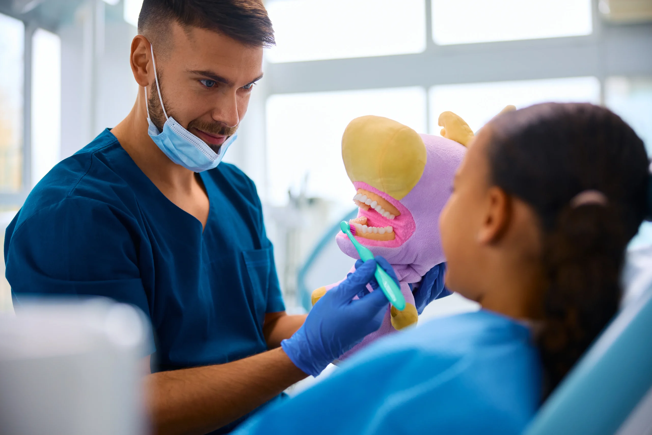 dentist-teaching-black-little-girl-to-brush-teeth-2024-12-13-18-35-40-utc